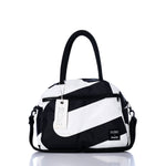Sea Bags Vintage Black and White Essential Weekender Travel Bag features bold diagonal stripes in black and white, two sturdy handles, a front zippered pocket, a detachable shoulder strap, and a signature white tag. Designed to elevate your travel style, this chic carryon or weekender bag stands elegantly on a reflective surface. by Sea Bags