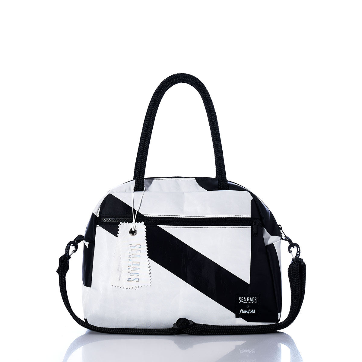 The Sea Bags Vintage Black and White Essential Weekender Travel Bag is showcased against a white background, featuring a bold geometric pattern, dual handles, a detachable shoulder strap, and a convenient trolley sleeve for effortless travel. by Sea Bags