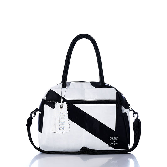 The Sea Bags Vintage Black and White Essential Weekender Travel Bag is showcased against a white background, featuring a bold geometric pattern, dual handles, a detachable shoulder strap, and a convenient trolley sleeve for effortless travel. by Sea Bags