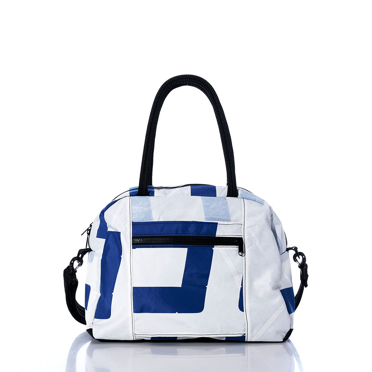 A Sea Bags Vintage Blue and White Essential Weekender Travel Bag, featuring a geometric pattern, black handles, a front zipper pocket, and a detachable shoulder strap, is displayed on a white reflective surface. by Sea Bags