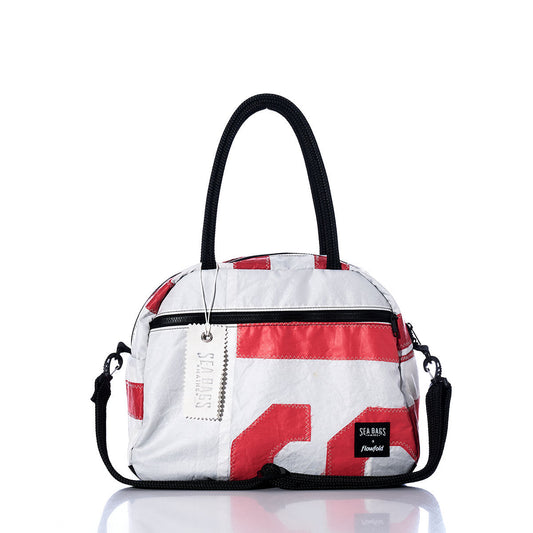 The Vintage Red Letters Essential Weekender Travel Bag by Sea Bags is a compact white and red handbag with black handles and a detachable strap, featuring a front zipper pocket and the signature Sea Bags label on the lower right corner—making it the perfect overnight or stylish carryon bag for your next getaway. by Sea Bags