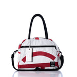 Introducing the Vintage Red and White Essential Weekender Travel Bag by Sea Bags. This stylish handbag features a striking red and white design with black handles, a detachable shoulder strap, a convenient front zipper pocket, and an authentic Sea Bags branded tag attached to one handle. Thoughtfully crafted as the ultimate weekender travel bag, it blends style and functionality—perfect for your next getaway. by Sea Bags