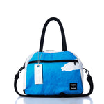 Elevate your travels with the Vintage Blue and White Essential Weekender Travel Bag from Sea Bags, featuring sturdy black handles, a detachable shoulder strap, a spacious front zipper pocket, and an authentic white Sea Bags tag—perfect as an overnight bag or your reliable go-to weekender travel companion. by Sea Bags