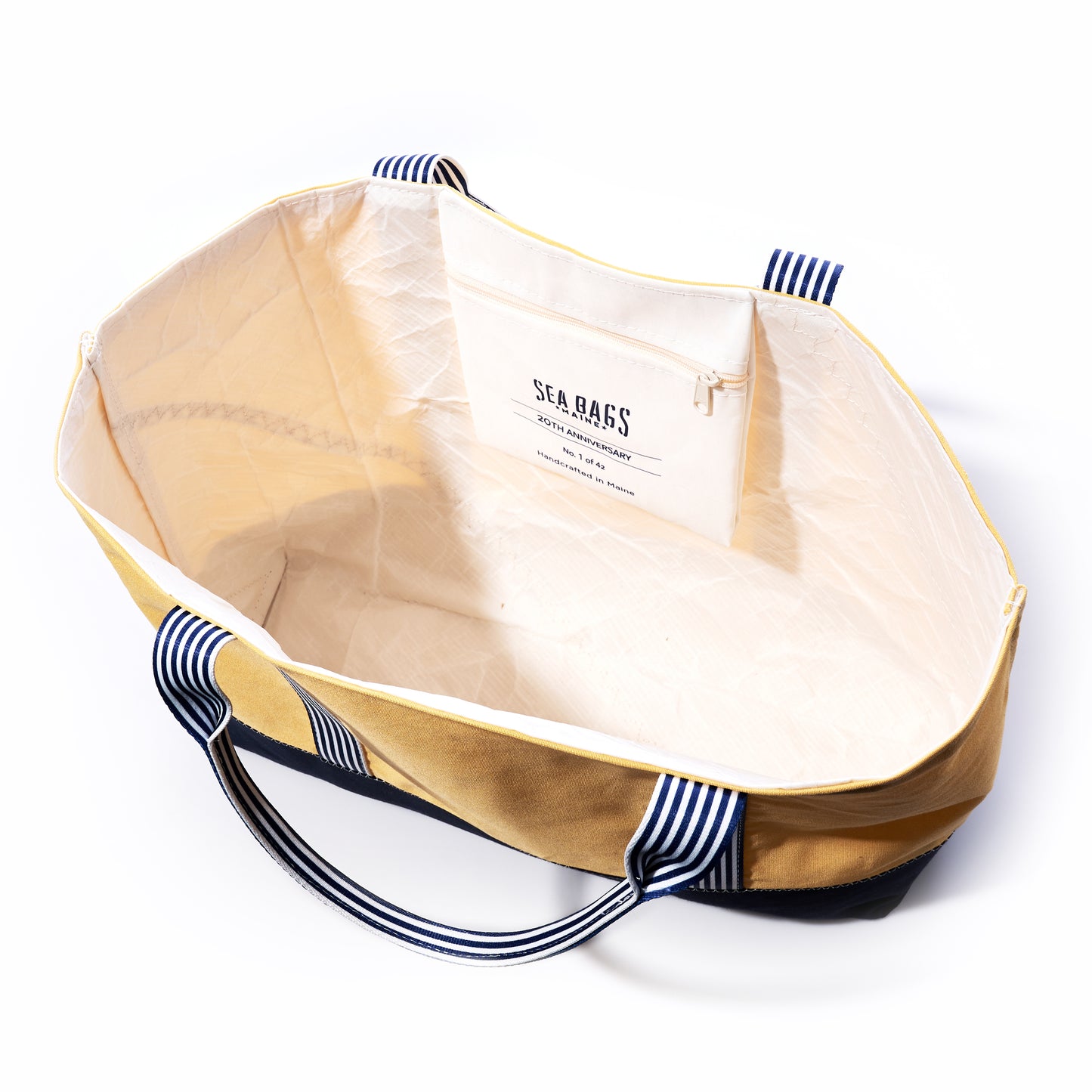 A large, empty Vintage Yellow Canvas Large Tote from Sea Bags, featuring striped handles and an inner pocket labeled with the brand name, is shown on a white background. This limited edition tote seamlessly blends style and functionality. by Sea Bags