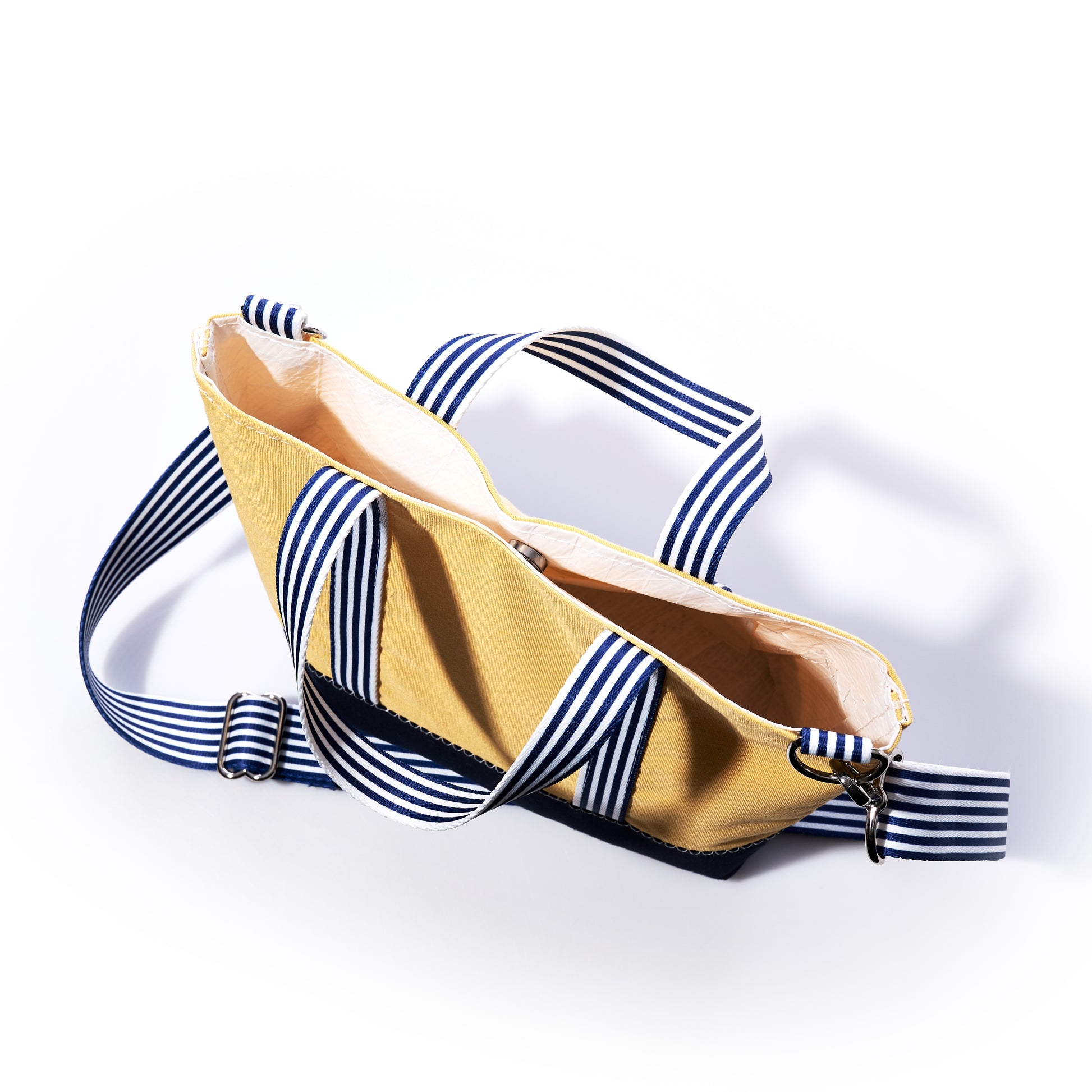 Sea Bags Vintage Yellow Canvas Crossbody Tote with blue and white striped handles and strap, shown from above with the top zipper partially open—a limited edition piece from our Heritage Collection Bag series. by Sea Bags