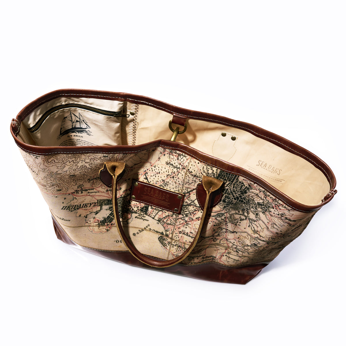 Introducing the Heritage Aello Large Tote by Sea Bags—a spacious bag with brown leather handles and trim, showcasing a vintage map print on both the exterior and lining. Inspired by the classic yacht restoration spirit and adventures aboard Greek sailing yacht S/Y AELLO, it features an interior zippered pocket for added convenience.