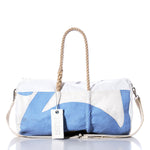 The Vintage Blue and White Duffel by Sea Bags is crafted from recycled sail cloth, featuring hemp rope handles, a detachable shoulder strap, and a Sail Bags tag attached to one handle, shown against a white background. by Sea Bags