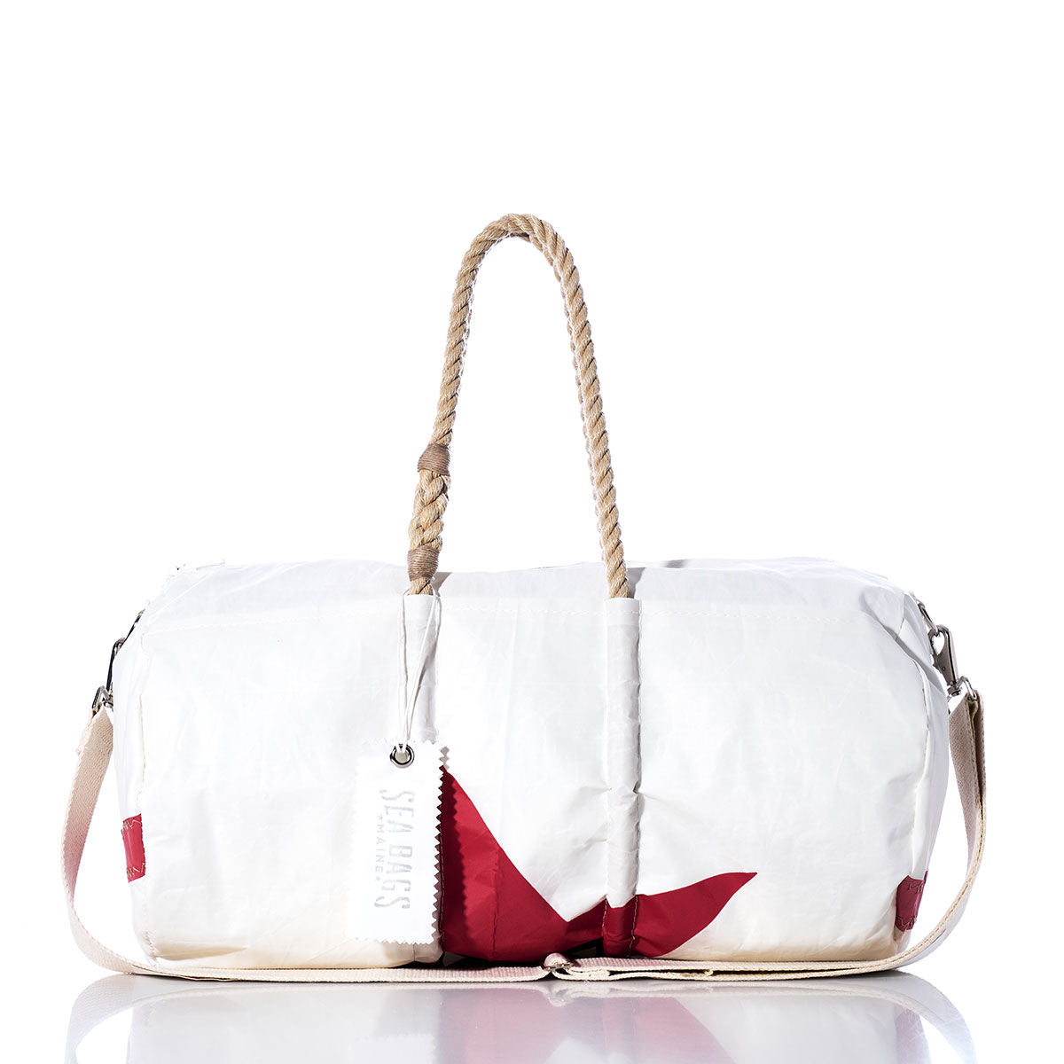 The Vintage Red Star Duffel by Sea Bags is a white duffel bag with red accents, featuring hemp rope handles, a beige shoulder strap, and a white tag labeled Sea Bags. Crafted from recycled sail cloth, it is shown against a white background. by Sea Bags