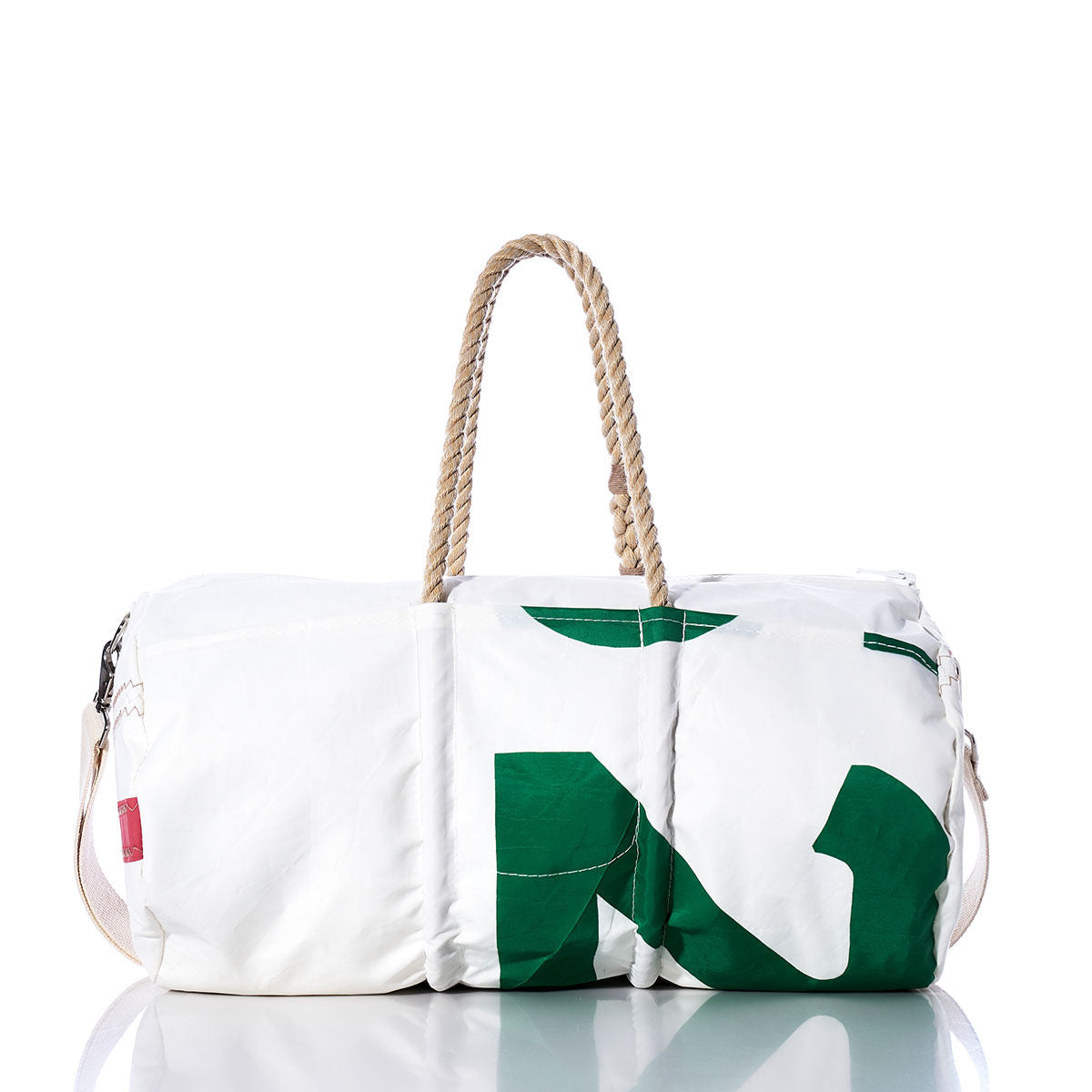 The Sea Bags Vintage 25 Duffel is a white bag with a green pattern, crafted from recycled sail cloth and adorned with distinctive sail insignias. It features sturdy rope handles and a convenient shoulder strap, shown on a reflective surface against a plain white background. by Sea Bags