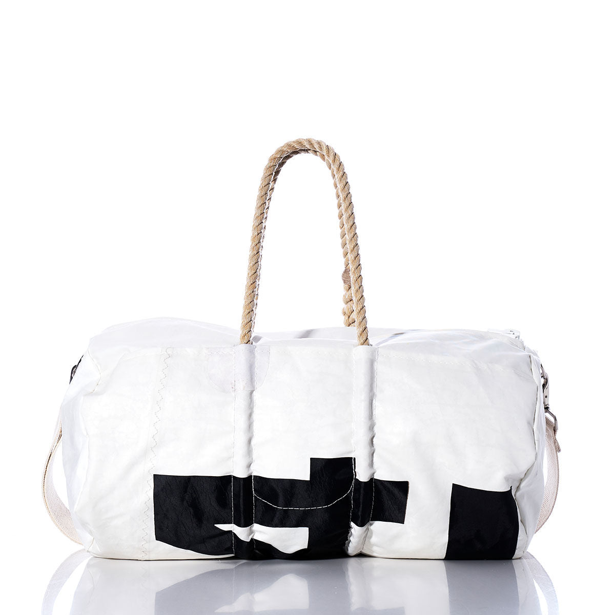 The Sea Bags Vintage International 14 Duffel is a white duffel bag featuring a black geometric design, beige rope handles, and a side strap. Expertly crafted from recycled sail cloth and adorned with subtle sail insignias, the bag is showcased on a white background with a reflection at its base. by Sea Bags