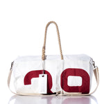 The Sea Bags Vintage 39 Duffel features a white exterior crafted from recycled sail cloth, accented with a bold red 20 graphic. It’s detailed with sturdy hemp rope handles, a beige strap, and a white tag—combining vintage-inspired design with modern style, all set against a clean white background. by Sea Bags