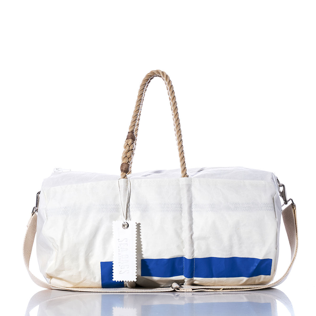 The Sea Bags Vintage 14 Duffel is a white duffel bag made from recycled sail cloth, featuring beige hemp rope handles, a blue stripe near the bottom, a shoulder strap, and a white tag, all showcased on a reflective surface. by Sea Bags