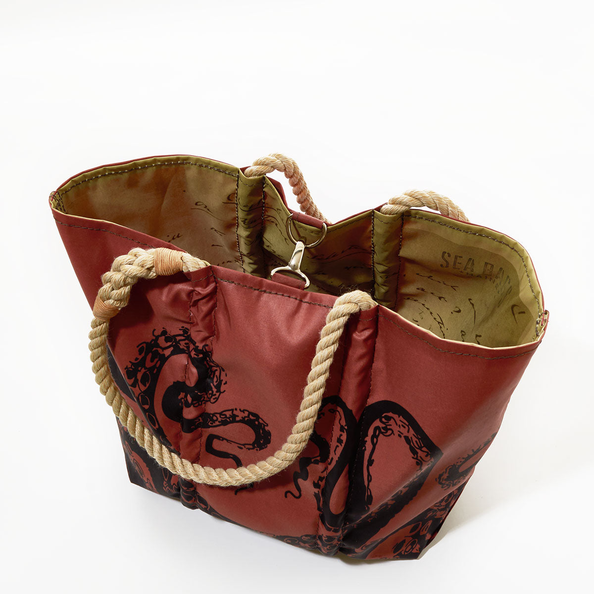 The Sea Bags Tanbark Octopus Medium Tote is a maroon bag made from recycled sail cloth, featuring sturdy rope handles and a bold black octopus design—shown from above on a white background, this unique accessory pays homage to classic tanbark bags. by Sea Bags