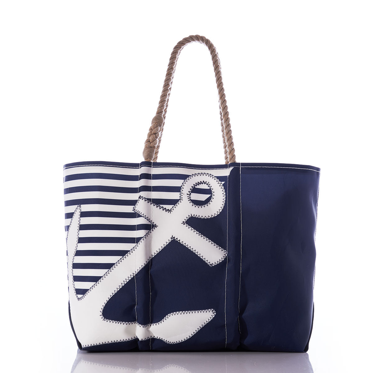 The Breton Stripe White Anchor Large Tote by Sea Bags is an eco-friendly accessory crafted from recycled sail cloth, featuring navy blue and white horizontal stripes, a bold anchor design on one side, and sturdy rope handles—perfect for stylish seaside adventures. by Sea Bags