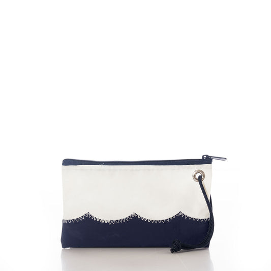 The Wavy Seas Wristlet by Sea Bags is a rectangular zippered pouch featuring a navy blue bottom, white top, scalloped seam, metal grommet, and navy wrist strap. Displayed on a white background, this sustainable accessory effortlessly captures nautical style. by Sea Bags