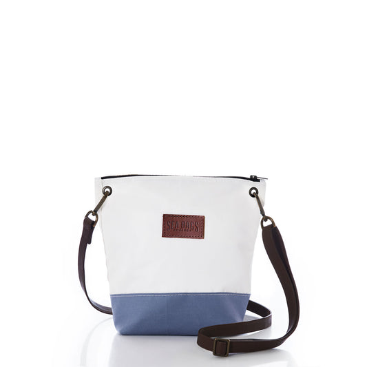 Chambray Blue Chebeague Crossbody Bag by Sea Bags, made from recycled sail cloth and featuring a white and blue canvas design, a brown adjustable strap, and a front leather patch embossed with the SEA BAGS logo, shown against a white background. by Sea Bags