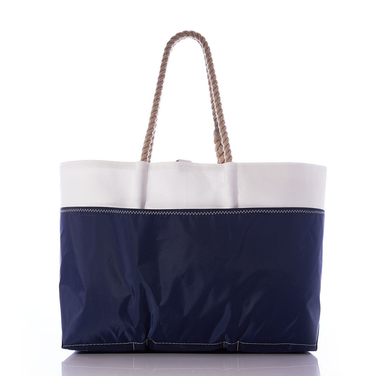 Sea Bags Navy Anchor Ogunquit Beach Tote featuring a white upper section, a navy blue lower section crafted from recycled sail cloth, and tan rope handles, displayed against a white background. by Sea Bags