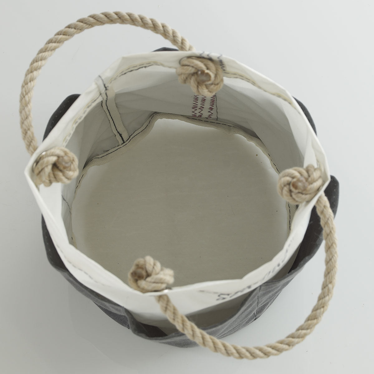 Top view of the All Purpose Gray Tool Bucket Bag by Sea Bags—an empty, round canvas bucket featuring thick rope handles and reinforced rim stitching, perfect for carrying gardening tools or serving as a durable tool bucket. by Sea Bags