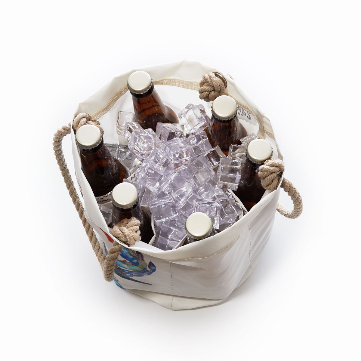 A Sea Bags Watercolor Crab Beverage Bucket filled with six brown glass bottles and ice cubes, viewed from above on a white background. by Sea Bags