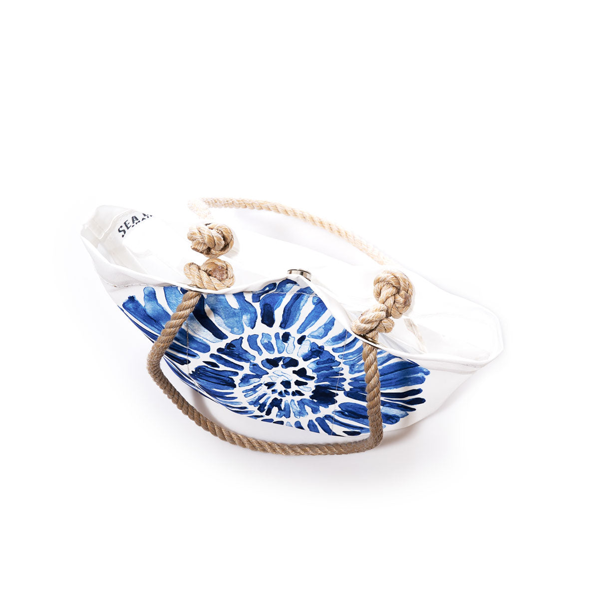 The Nautilus Print Essential Handbag by Sea Bags features a blue nautilus-inspired design on white recycled sail cloth, beige rope handles, and the brand’s signature SEA logo on the upper left edge, making it a sustainable handbag option. The bag is photographed on a white background. by Sea Bags