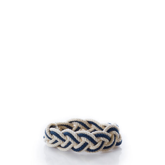 The Nantucket Knotworks Racing Stripes Bracelet - Navy/Natural by Nantucket Knotworks is elegantly displayed against a white background, featuring intricately intertwined navy and natural rope. This authentic bracelet exemplifies timeless nautical style and exceptional artisanal craftsmanship. by Sea Bags