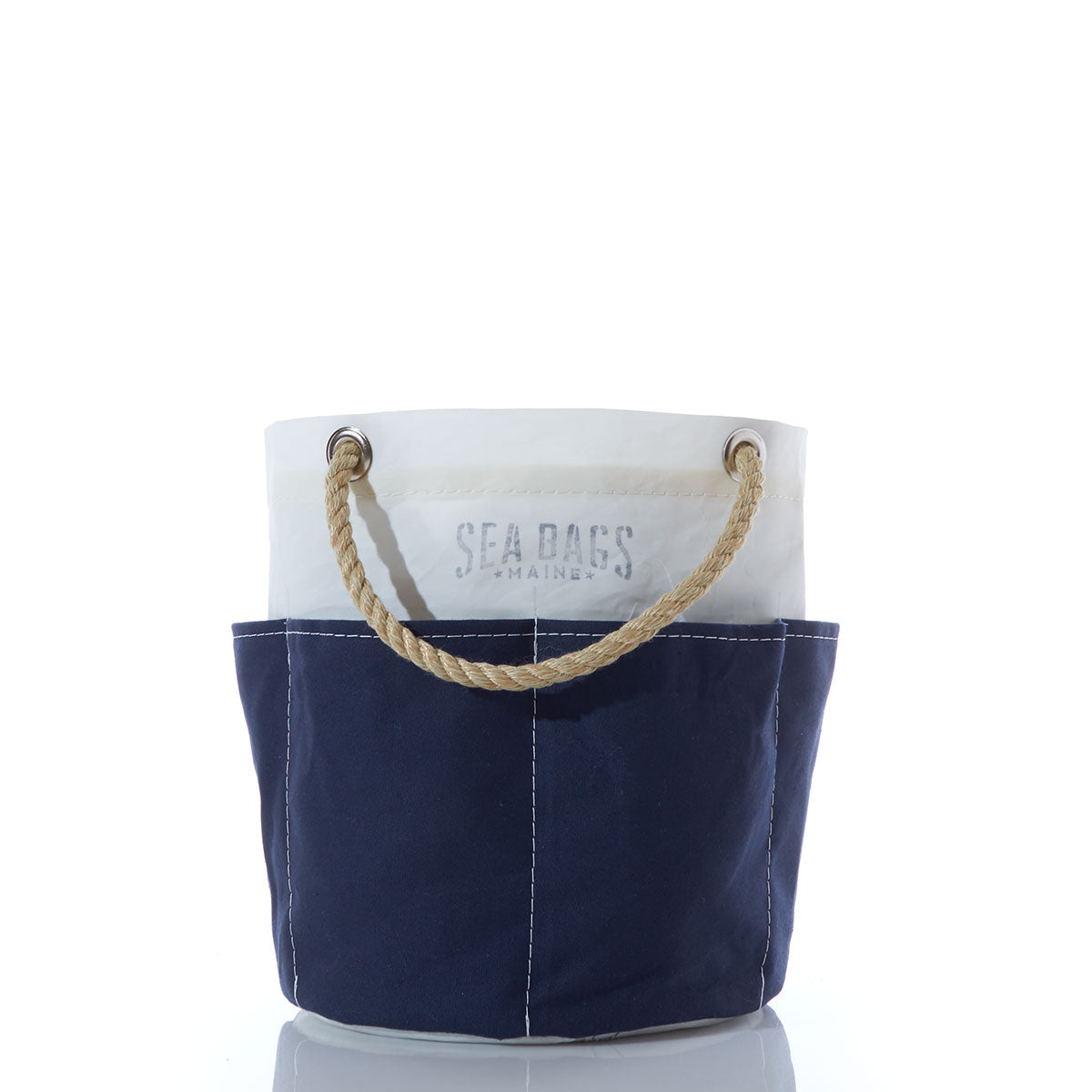 Introducing the Sea Bags All Purpose Navy Tool Bucket Bag—a small, two-tone canvas bucket bag featuring a sturdy rope handle, perfect for stylishly carrying your gardening tools. The top half is white with Sea Bags printed on it, while the bottom half is navy blue. by Sea Bags