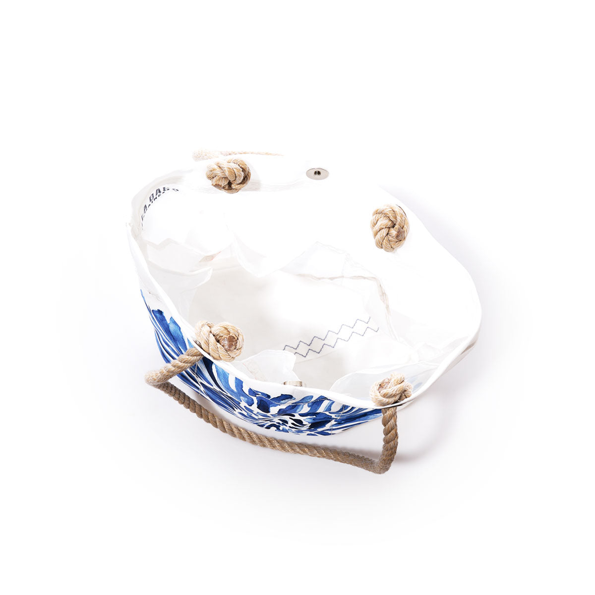 Sea Bags Nautilus Print Essential Handbag, handcrafted from recycled sail cloth with white and blue canvas, rope handles, and knotted rope accents, offers a truly sustainable option—shown from above on a white background. by Sea Bags