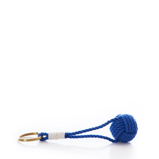 Mystic Knotwork’s Monkey’s Fist Keychain-Cobalt, crafted from durable cotton cord in a classic seafaring knot and finished with a gold key ring, is displayed horizontally on a white background.