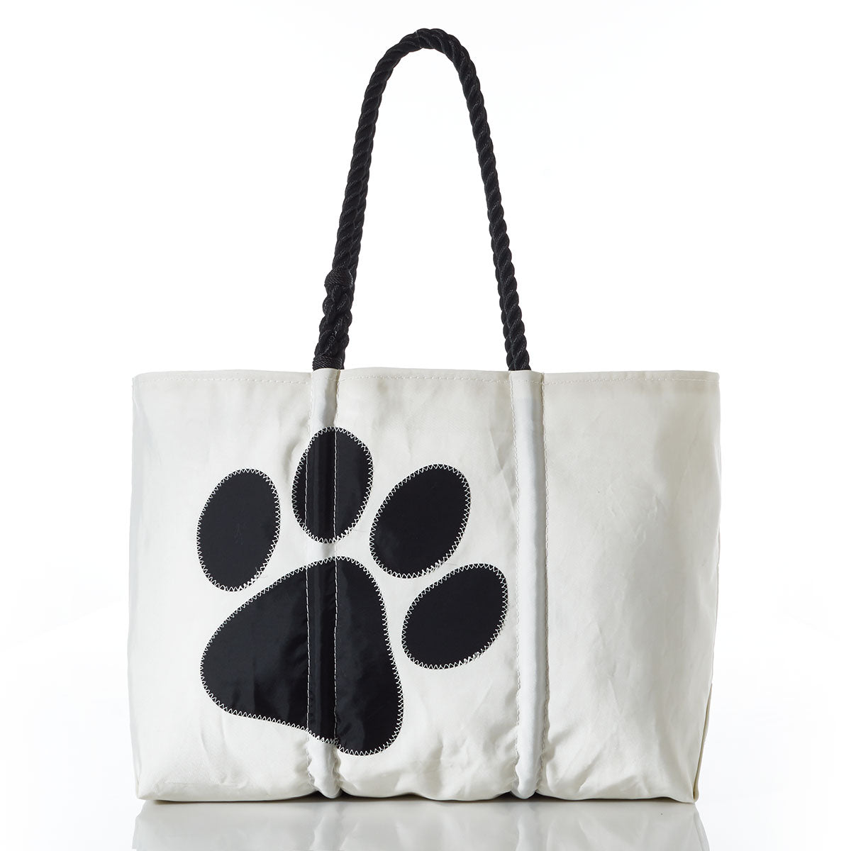 The Paw Print Large Tote with Clasp and Hanging Pocket by Sea Bags features black rope handles and a bold black paw print on white recycled sailcloth—an ideal accessory for dog lovers or as an organizer for pet supplies. by Sea Bags