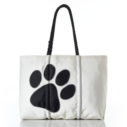 The Paw Print Large Tote with Clasp and Hanging Pocket by Sea Bags features black rope handles and a bold black paw print on white recycled sailcloth—an ideal accessory for dog lovers or as an organizer for pet supplies. by Sea Bags