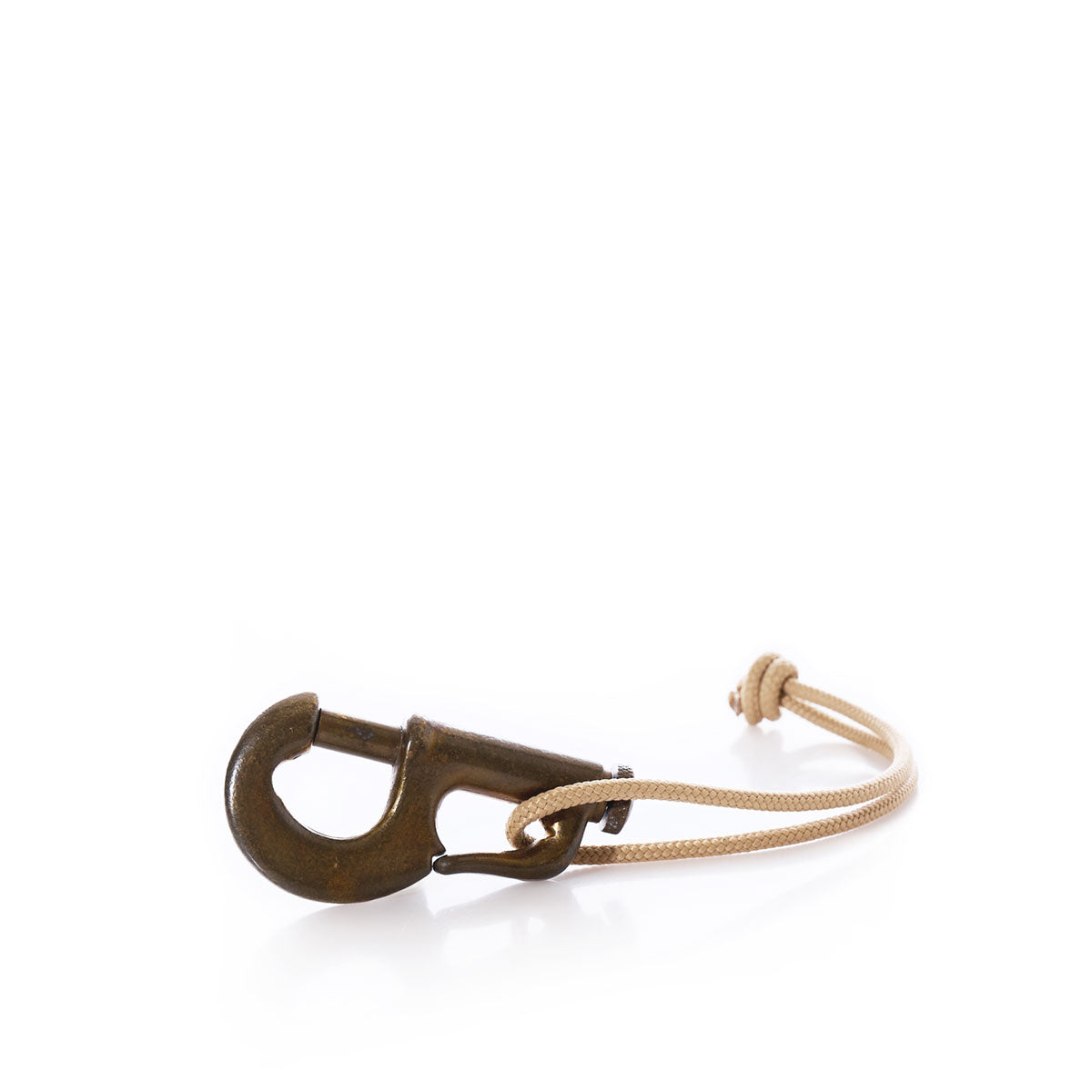 A classic piece of Vintage Sailmakers Hardware, featuring a brass jib hank snap hook paired with a beige hemp cording threaded through its eye, displayed on a white background. by Sea Bags
