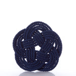 A Nautical Sailor Knot Trivet in navy, expertly crafted by Mystic Knotwork, tied in an intricate decorative knot and displayed against a white background—a stunning showcase of the brand’s craftsmanship.