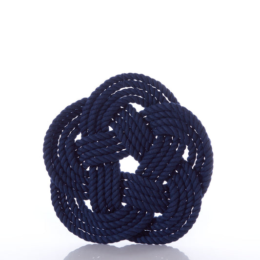 A Nautical Sailor Knot Trivet in navy, expertly crafted by Mystic Knotwork, tied in an intricate decorative knot and displayed against a white background—a stunning showcase of the brand’s craftsmanship.