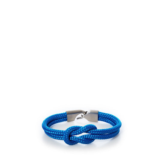 Introducing the Square Knot Bracelet - Blue from Lemon  Line, featuring a blue braided nautical design with a central knot and silver-toned metal clasp, showcased against a white background—a perfect summer accessory. by Sea Bags