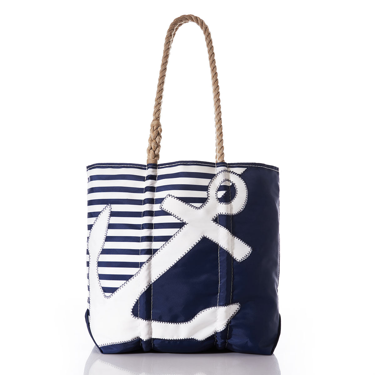 The Sea Bags Breton Stripe White Anchor Medium Tote is a handcrafted navy blue and white nautical tote with rope handles, featuring horizontal stripes at the top and a large white anchor design on the front, made in Portland from recycled sail cloth. by Sea Bags
