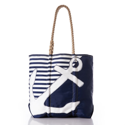 The Sea Bags Breton Stripe White Anchor Medium Tote is a handcrafted navy blue and white nautical tote with rope handles, featuring horizontal stripes at the top and a large white anchor design on the front, made in Portland from recycled sail cloth. by Sea Bags
