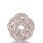 The Nautical Sailor Knot Trivet-Natural by true features a neatly coiled, off-white cotton rope tied in a decorative, flat, circular Turk’s head knot against a plain white background.