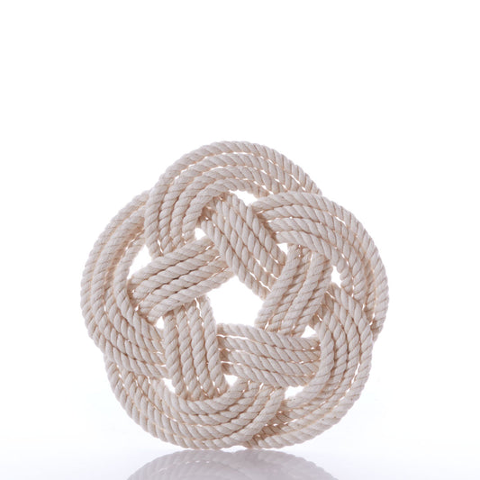 The Nautical Sailor Knot Trivet-Natural by true features a neatly coiled, off-white cotton rope tied in a decorative, flat, circular Turk’s head knot against a plain white background.