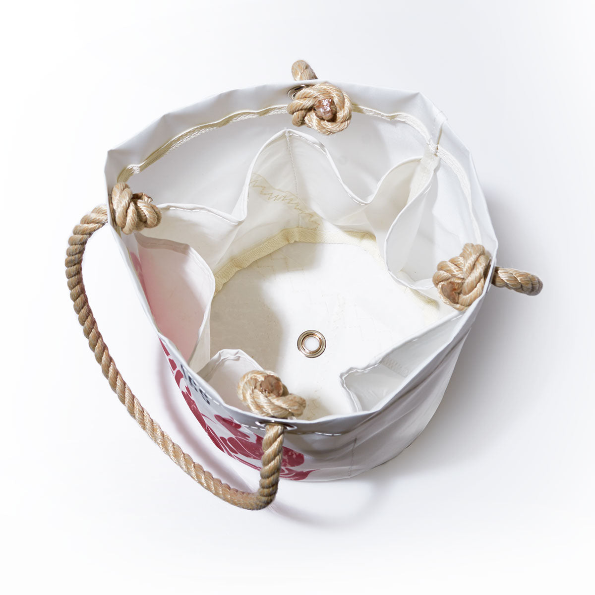 Open, empty Lobster Pound Beverage Bucket Bag by Sea Bags with rope handles and a floral pattern, viewed from above, crafted from recycled sail cloth, featuring interior pockets and a metal grommet at the bottom. by Sea Bags