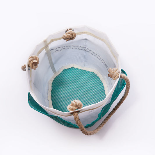 Top view of an empty, cylindrical Sea Bags Ocean Teal Gardeners Bucket Bag featuring a durable mesh bottom and thick rope handles, set against a plain white background—perfect for storing your gardening essentials. by Sea Bags