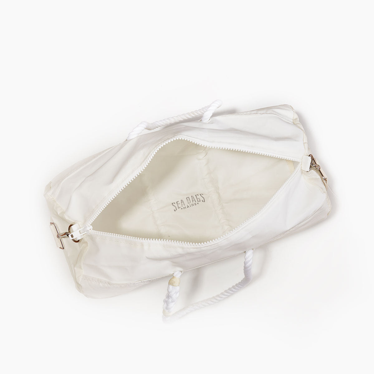 Vertical Striped Navy Duffel Bag by Sea Bags, crafted from recycled sail cloth with sturdy rope handles, unzipped to reveal its interior lining and SEA BAGS logo printed inside, photographed from above on a white background. The marine grade zipper ensures durability and secure closure. by Sea Bags