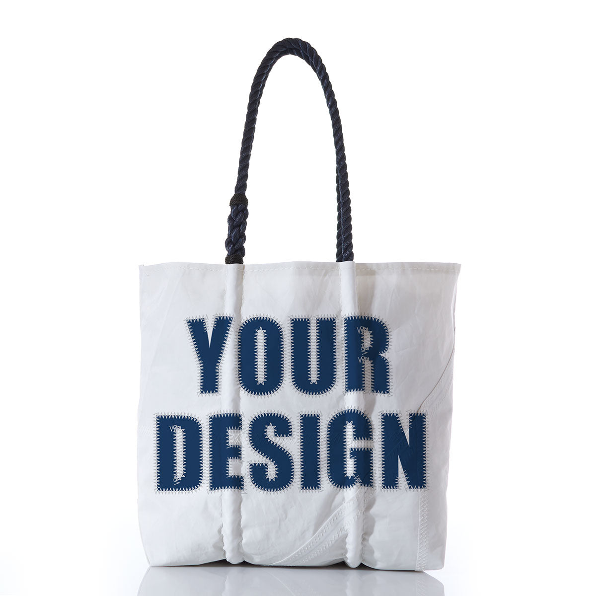 Sea Bags’ Custom Design Medium Tote features dark rope handles and bold navy YOUR DESIGN lettering across the front. This personalized tote is shown against a white background with a subtle reflected surface below. by Sea Bags
