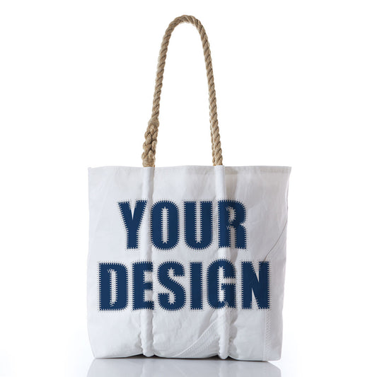 Sea Bags Custom Design Medium Tote features thick rope handles and YOUR DESIGN printed in bold navy letters on the front. Photographed against a white background, this durable and stylish tote is inspired by the classic look of reclaimed sail bags—perfect for everyday use. by Sea Bags