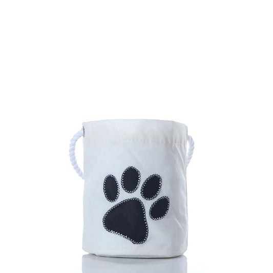 The Sea Bags Paw Print Bucket Bag features a white fabric design with rope handles and a large black paw print applique on the front, making it perfect as a pet storage bucket or dog toy organizer. Photographed against a white background. by Sea Bags