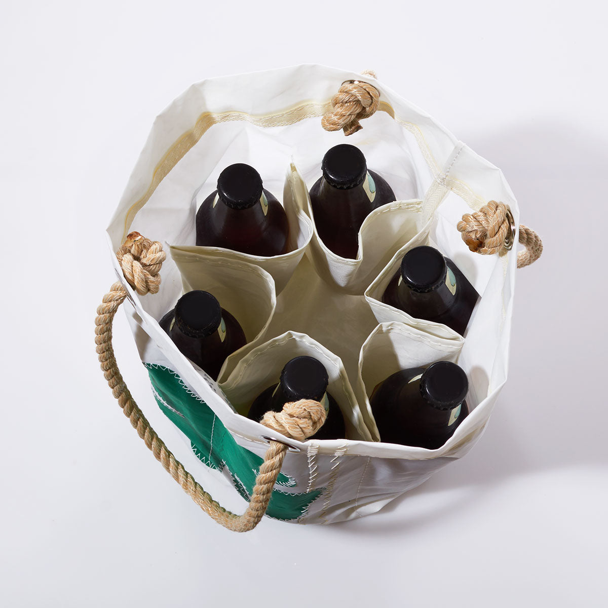 Top view of the Sea Bags Four Leaf Clover Beverage Bucket Bag, a white tote featuring rope handles and crafted from recycled sail cloth, holding six dark bottles each separated by individual compartments. by Sea Bags