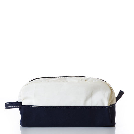 The Sea Bags Chebeague Toiletry Bag is a rectangular zippered pouch from the Chebeague collection, crafted with durable Dacron sailcloth. Featuring a white top, dark blue bottom, visible stitching, and a side handle that reflects the design of classic seaworthy travel bags, it is shown against a white background. by Sea Bags