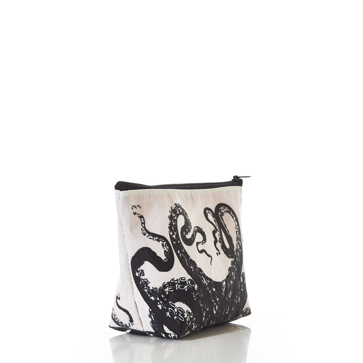 The Sea Bags Octopus Cosmetic Bag, crafted from recycled sail cloth and featuring a bold black and white octopus design, stands upright on a white reflective surface. by Sea Bags