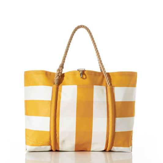 The Yellow Pier Tote by Sea Bags is a yellow and white striped bag with rope handles, made from recycled sail cloth and designed with a large exterior pocket. The tote stands upright on a white surface, set against a plain white background. by Sea Bags