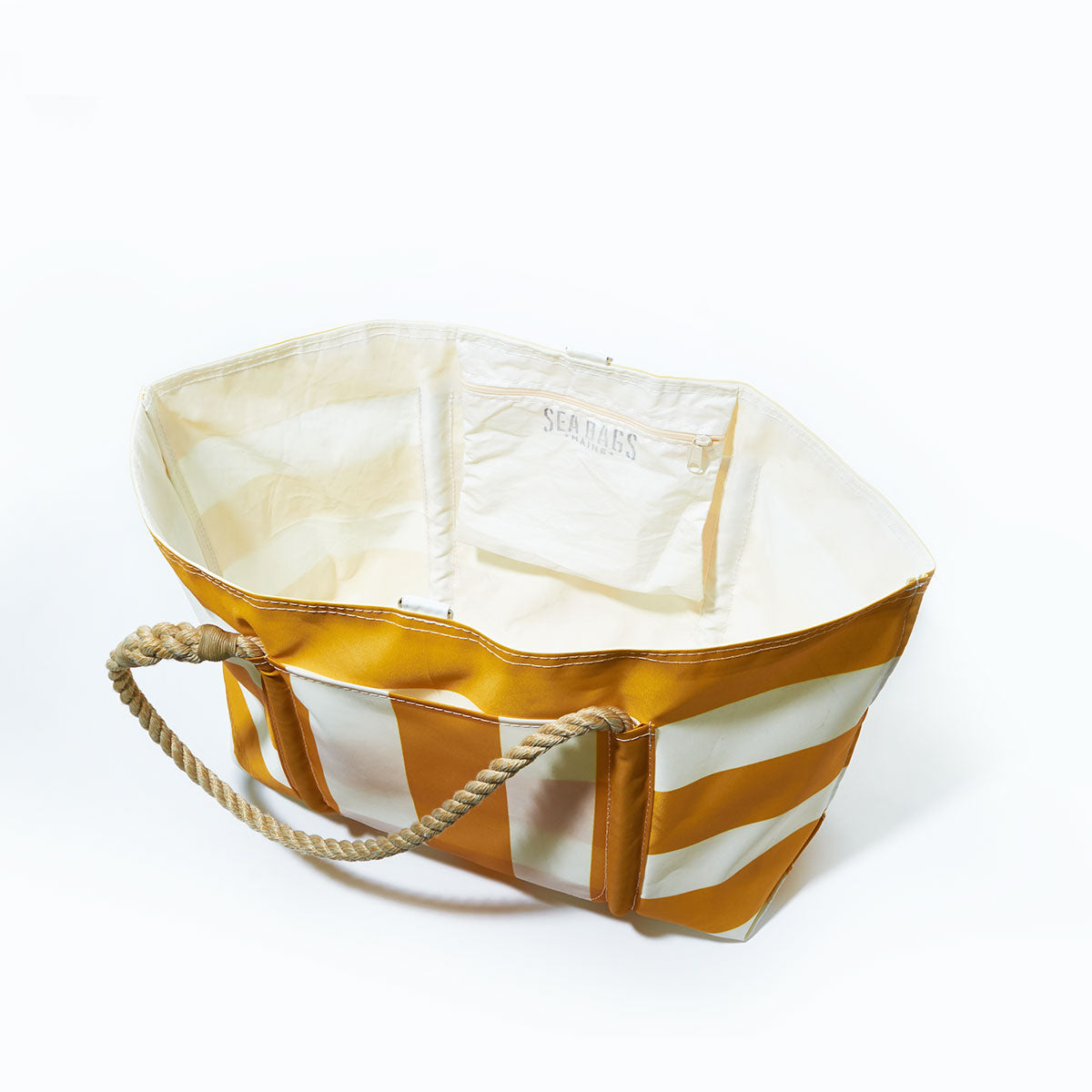 The Sea Bags Yellow Pier Tote is a large open tote bag with yellow and white stripes, crafted from recycled sail cloth. It features rope handles, an inner pocket, and a spacious exterior pocket, all set against a white background. by Sea Bags
