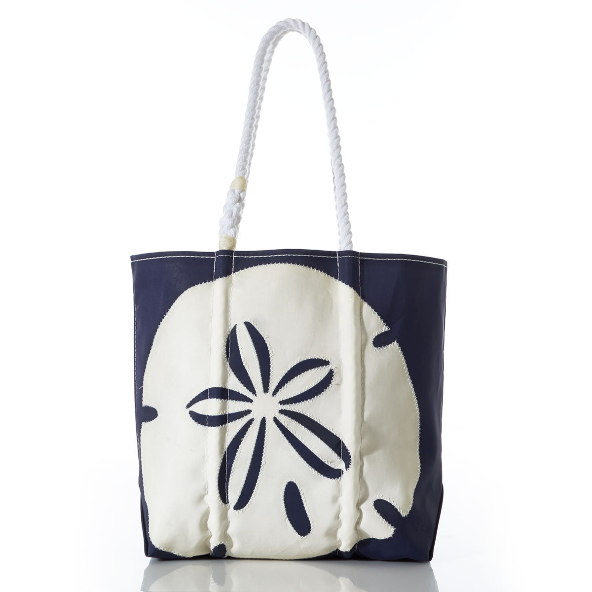 The Sea Bags White on Navy Sand Dollar Medium Tote is an eco-friendly navy blue tote bag made from recycled sails, featuring sturdy white rope handles and a bold white sand dollar design on the front. Photographed against a white background, this stylish and sustainable bag is perfect for your everyday adventures. by Sea Bags